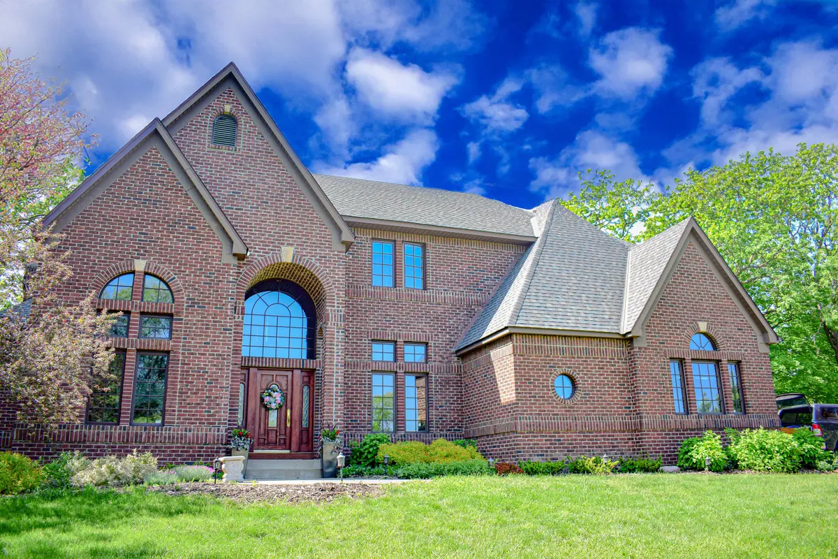 Premium brick home with a complex, multi-plane roof completed by Smart Builders
